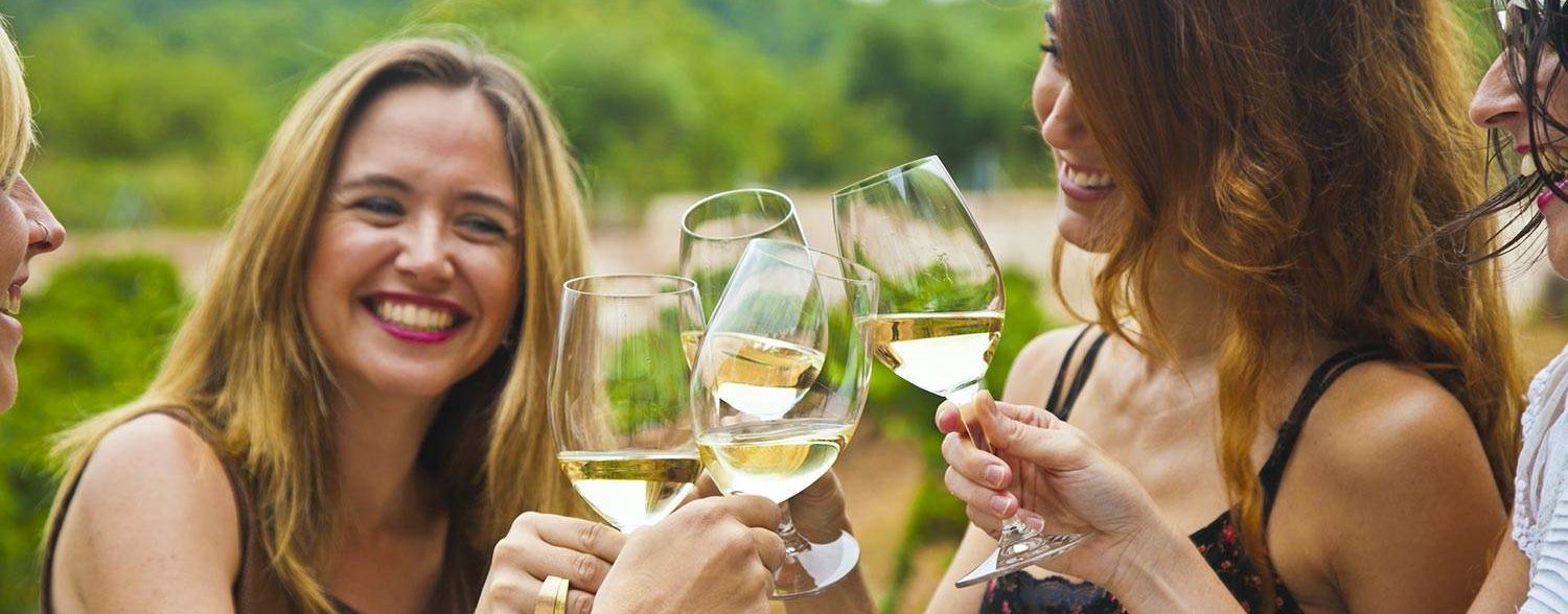 personas brindando con vino blanco